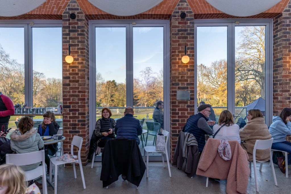Visitors sitting beside the tall windows in William Morris Gallery’s café