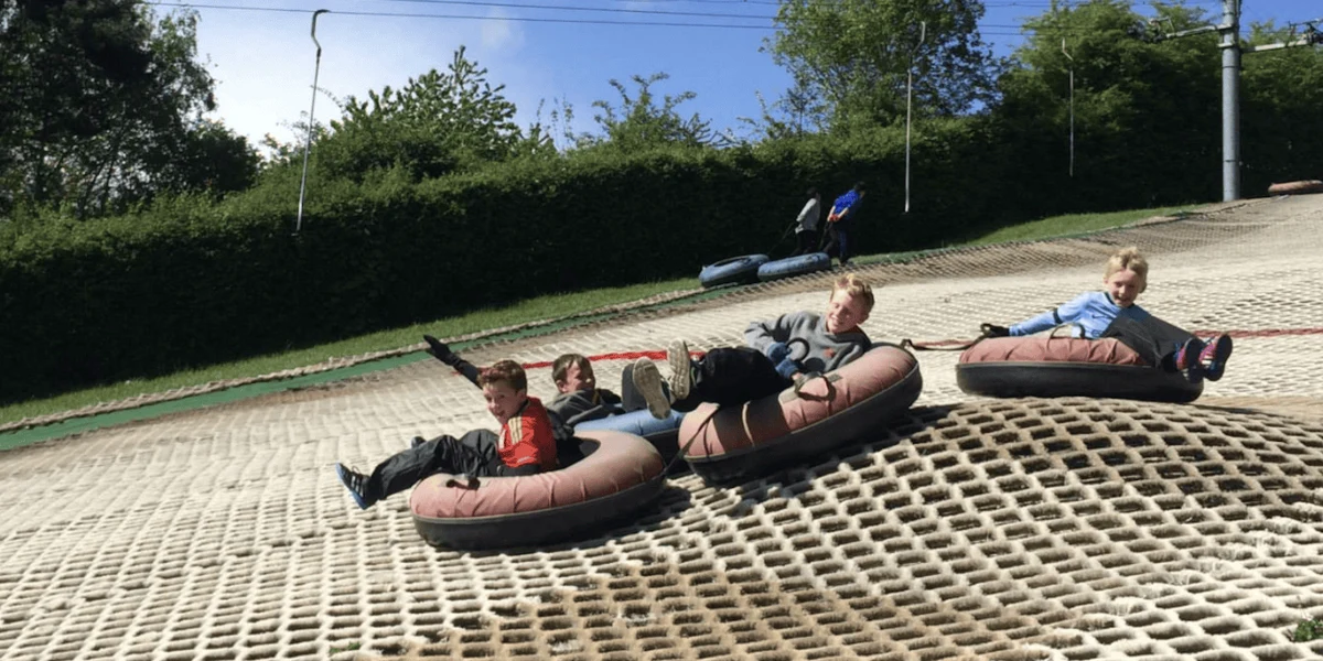 Children riding inflatable tubes on the artificial slope at Cardiff Ski & Snowboard Centre in Fairwater.