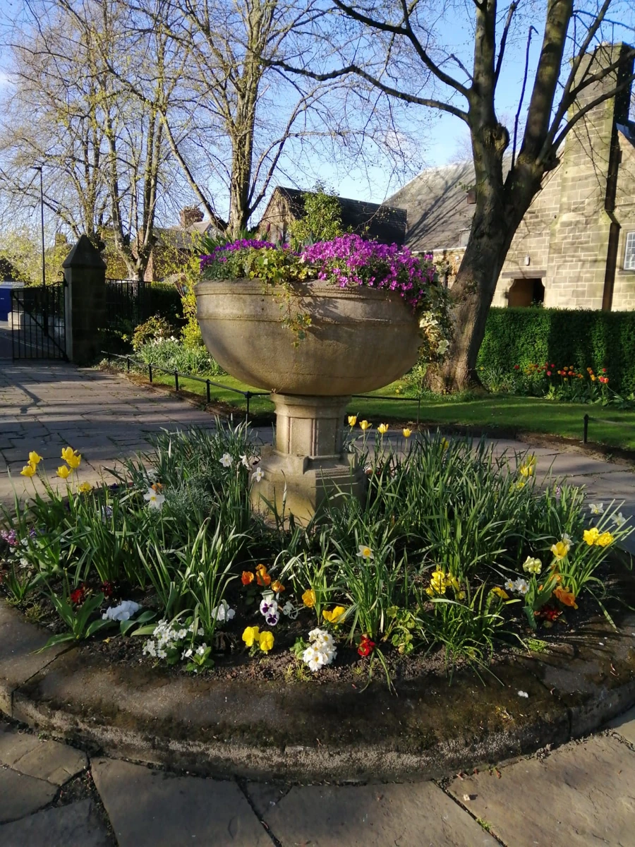 A stone planter and flower beds beside St James and St Basil’s Church in Fenham