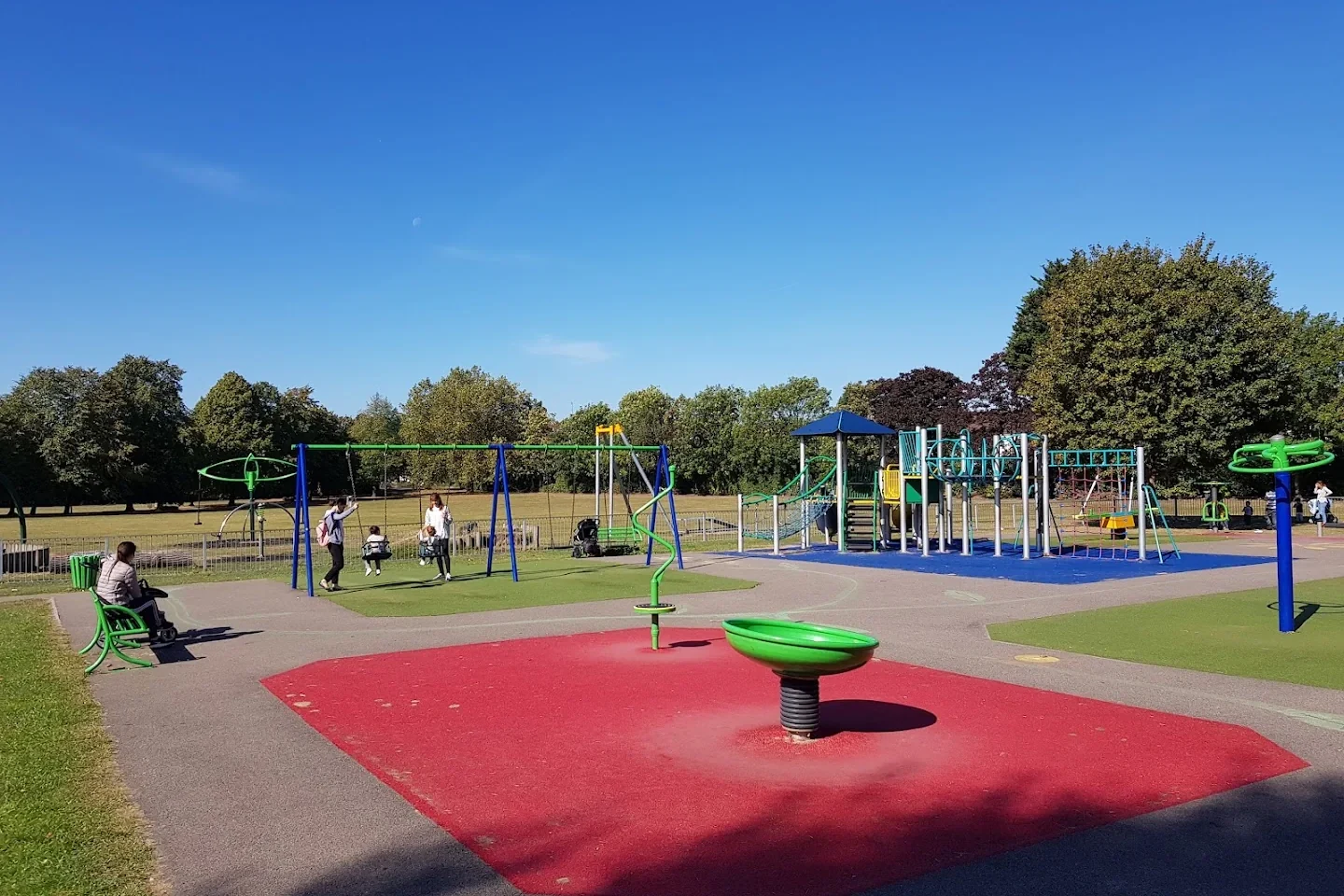 Roundabout and swings in the playground at Memorial Park, Chingford