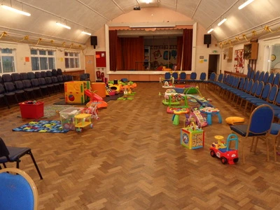 Toys and ride-ons arranged in Morriston Memorial Hall for the Beginnings toddler group