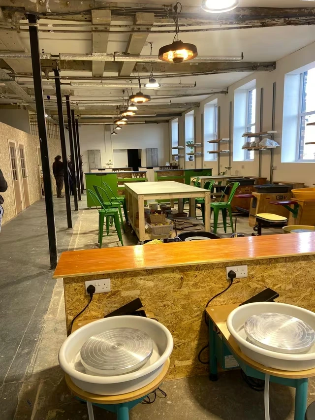 Worktables and green chairs inside Firefly Pottery’s Bramley studio