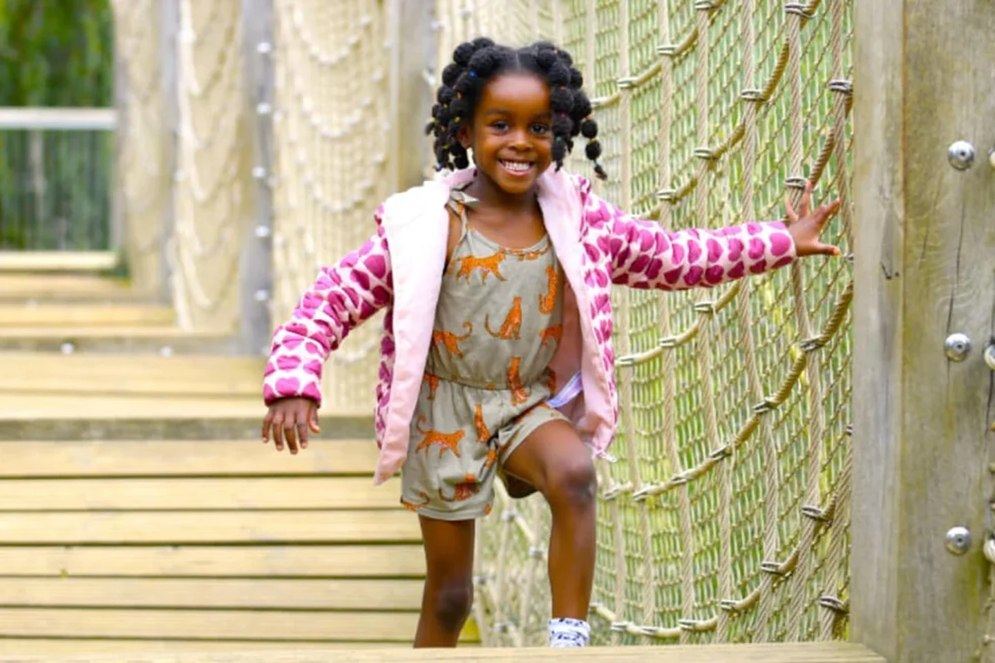 A child crossing the rope bridge at Tumbling Bay Playground