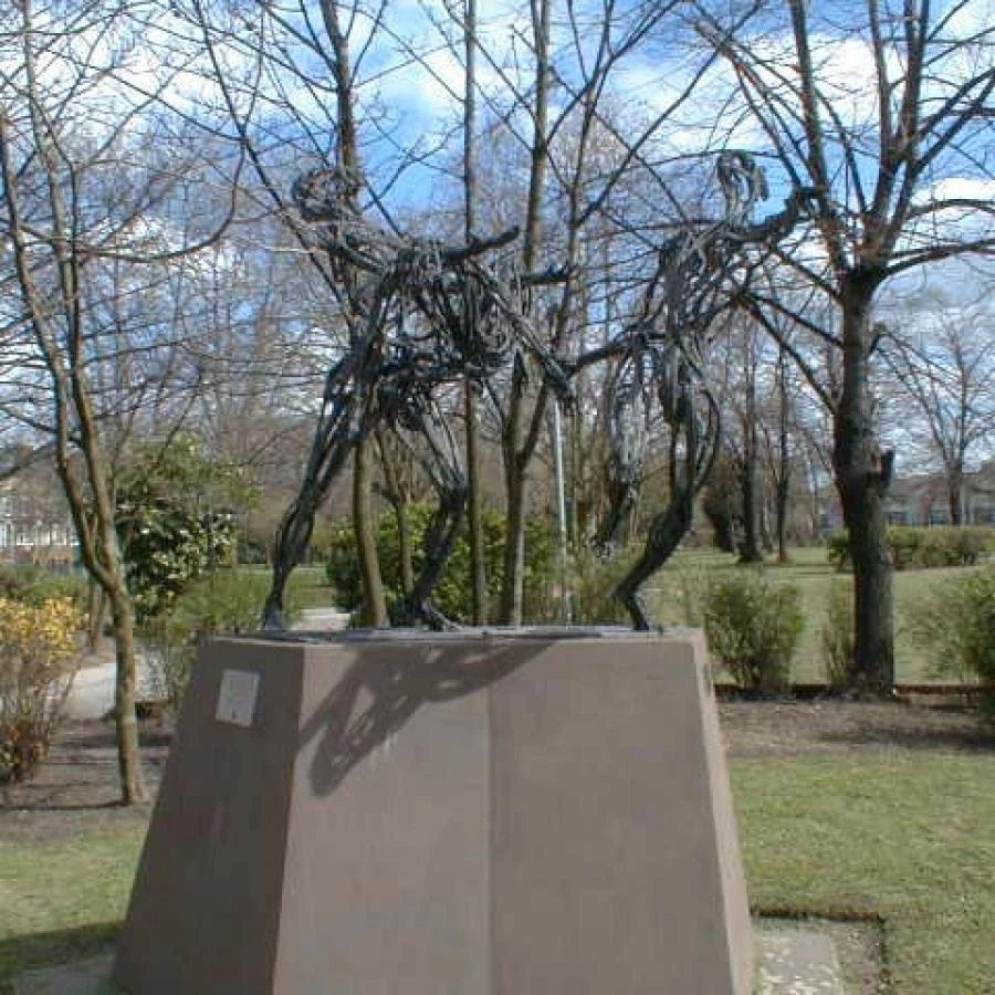Soweto uprising memorial on a plinth among trees and lawns in Max Roach Park