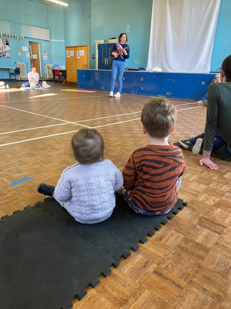Musical Miniatures provider class with ukulele, children and carers; not a Halloween-session photograph