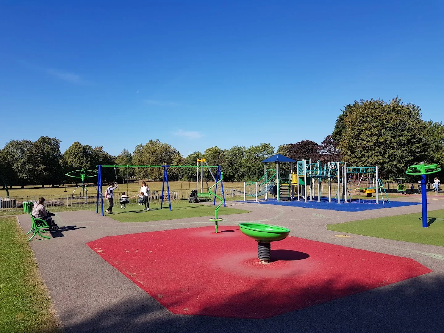 Roundabout and swings in the playground at Memorial Park, Chingford