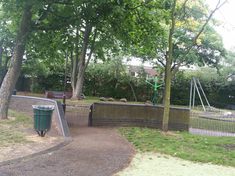 Tree-lined path and play area at Cann Hall Park