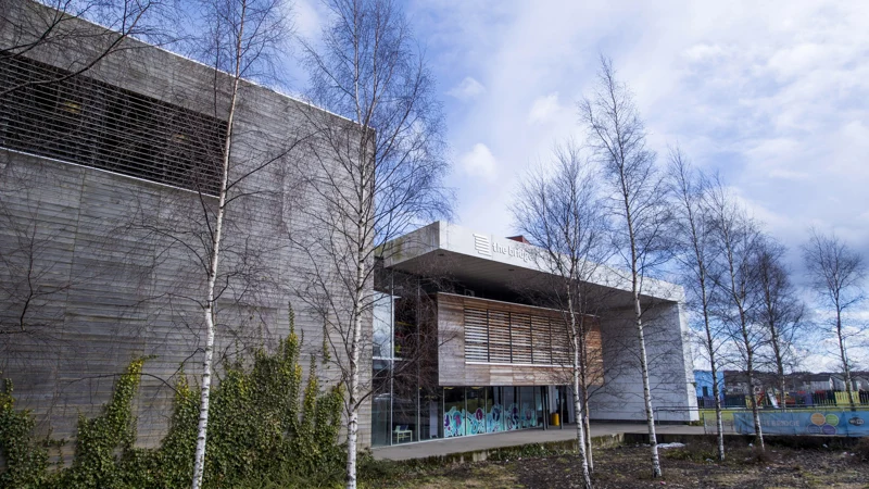 Timber-clad exterior of Library at The Bridge with bare trees and a glazed lower level