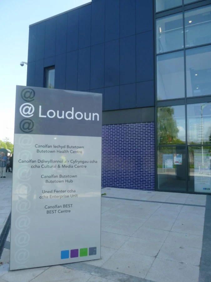 The Loudoun sign naming Butetown Hub beside the blue-clad community building