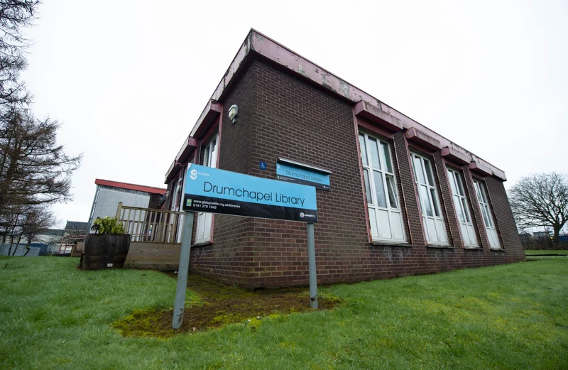 The brick exterior and tall white windows of Drumchapel Library, with its blue library sign