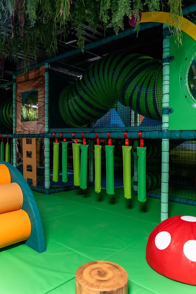 Green padded climbing frame and tunnel at Play Central.