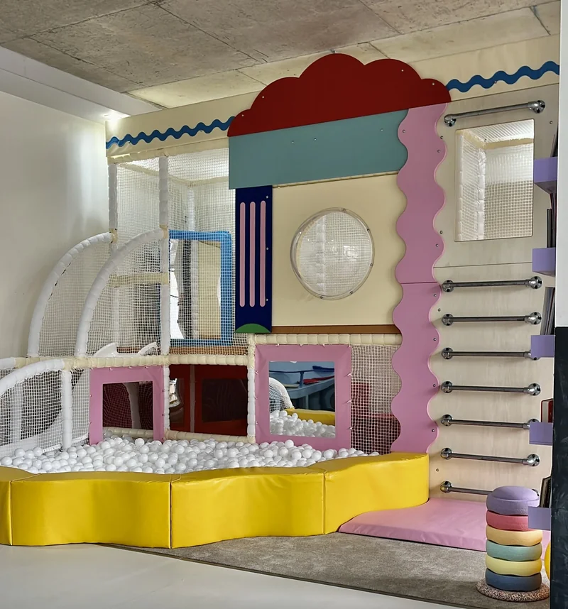 The colourful climbing frame and white-ball pit at It Takes a Village Play Cafe.